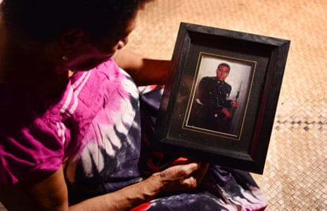 73 year old Nainasa Roiroi (also known as Nainasa Valetabua) holding a framed photograph of her son Taitusi Ratucaucau at her home in Lami, Fiji. Picture: Jovesa Naisua/The Guardian