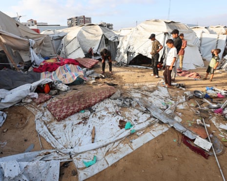 Palestinians inspect the damage at the site of an overnight Israeli airstrike that hit a tent sheltering displaced people, in Khan Younis, southern Gaza Strip, July 12, 2025.