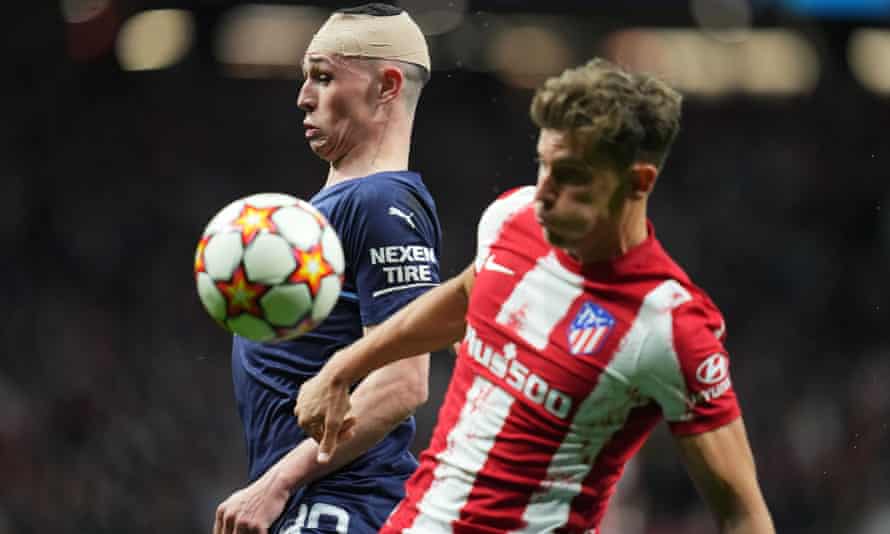 A bandaged Phil Foden battles Marcos Llorente for the ball