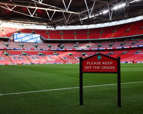 Empty Wembley Stadium pitch with a 'Please keep off the grass' sign