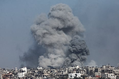 Smoke rises following an Israeli airstrike in central Gaza, as seen from southern Israel, 23 November.