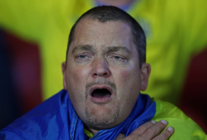 Ukraine fan looks emotional singing their national anthem.