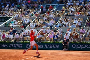 The crowd watch Novak Djokovic fire off a forehand.