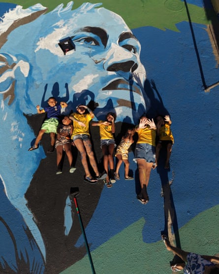 Children on on a painting of footballer Neymar’s face in Saint Luke square.