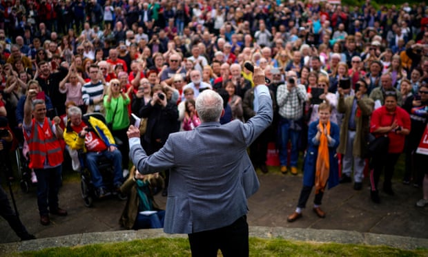 Jeremy Corbyn, with his back to the camera, addresses a rally in Bootle, Merseyside.