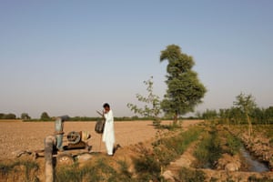 Leman Raj, 40, stands beside a draining pump used in the chili pepper fields, following rains and floods during monsoon season in Kunri, Umerkot, Pakistan, 15 October, 2022