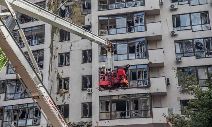 Los bomberos trabajan para apagar un incendio mientras el humo se eleva desde un edificio residencial