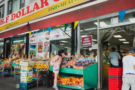 John Xie reaches for produce outside a grocery store in Queens.