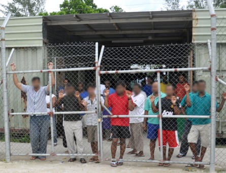Asylum seekers housed in Delta compound look on from behind a fence as a court appointed party inspects the Manus Island detention centre in Papua New Guinea.