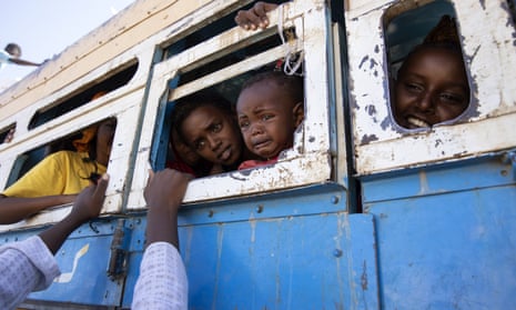 Refugees who fled the conflict in Ethiopia's Tigray region ride a bus going to a temporary shelter, near the Sudan-Ethiopia border, in Hamdayet, eastern Sudan on 1 December, 2020. 