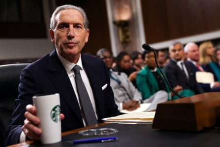 Man holds a Starbucks mug while testifying before a Senate committee.