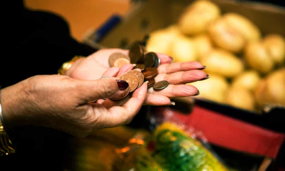 A person buying food with worn coppers