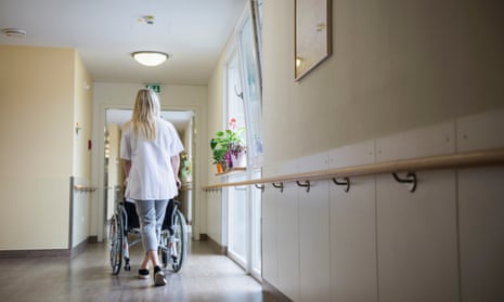 Person pushing wheelchair in care home