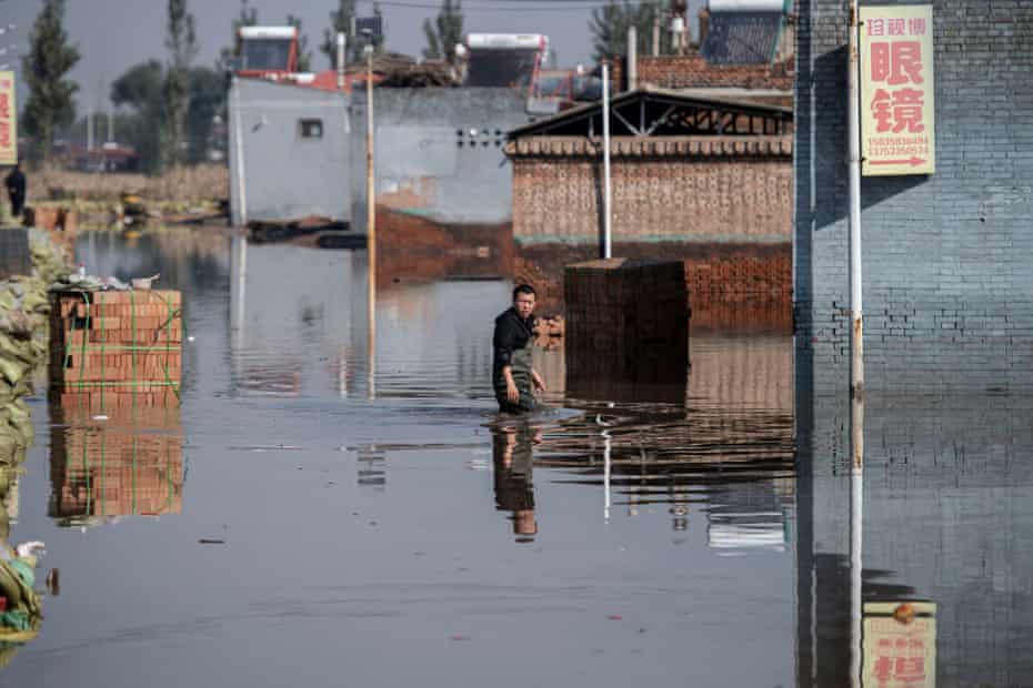 A man makes his way along a flooded area after heavy rainfall in Jiexiu in the city of Jinzhong, Shanxi province.