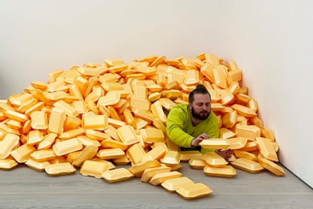A man amid a huge pile of orange takeaway food cartons in the corner of a room