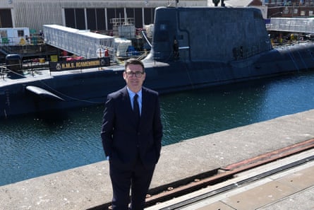 Andy Burnham stands in front of a submarine in a dock at BAE Systems in Barrow in Furness, Cumbria.