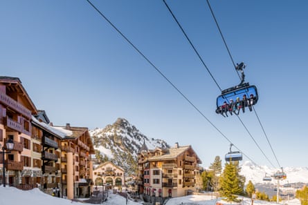 A snowy ski village with ski lifts above