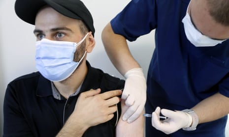 A man receives a shot of vaccine against COVID-19 disease.