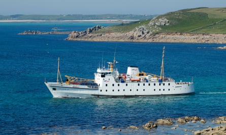 an old-fashioned ferry with a single funnel moored close to shore in a blue sea