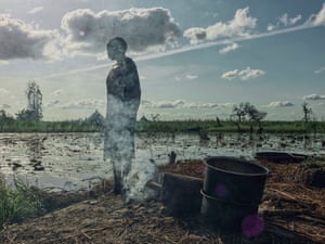 Angeline Nyabieli, 50, cozinha em casa em sua ilha de grama na vila de Paguir