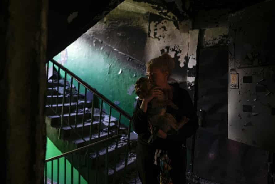 Olga Chernenko, 51, holds her dog Casper, at the entrance of her home ruined by attacks in Irpin, on the outskirts Kyiv, Ukraine.