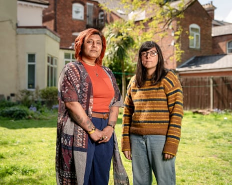 Jessica Thiari and Sharonjit Sutton stand side by side on a lawn at the back of residential buildings