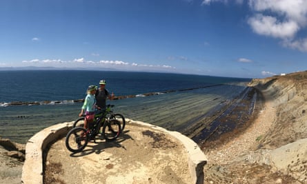 couple on ebikes with coastal view