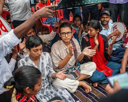 Neha Bora sitting amid a group of other protesters on a blanket at a demonstration