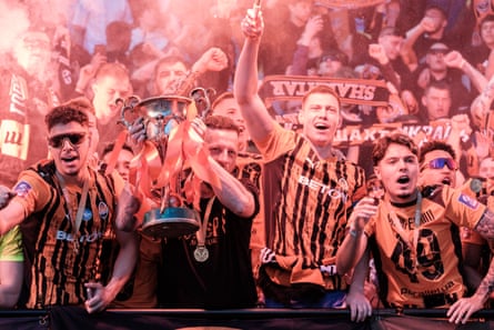 A Shakhtar Donetsk fan joins the players as they celebrate winning the Ukrainian Premier League in May 2026.