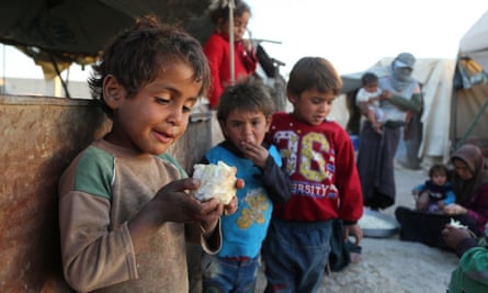 A Syrian child holds a piece of cauliflower at the Ash’ari camp for displaced people in the rebel-held eastern Ghouta area, outside Damascus