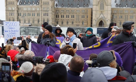 A woman speaking into a megaphone surrounded by people