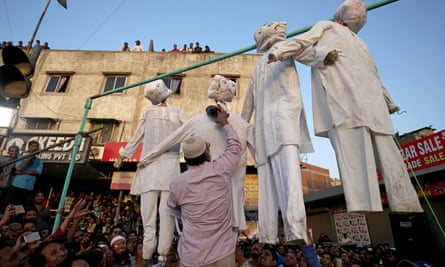 A man beats an effigy of one of the rapists at a protest against three rapes of girls, in Ahmedabad, India.
