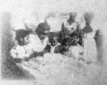 A black woman surrounded by children, outlined in sugar