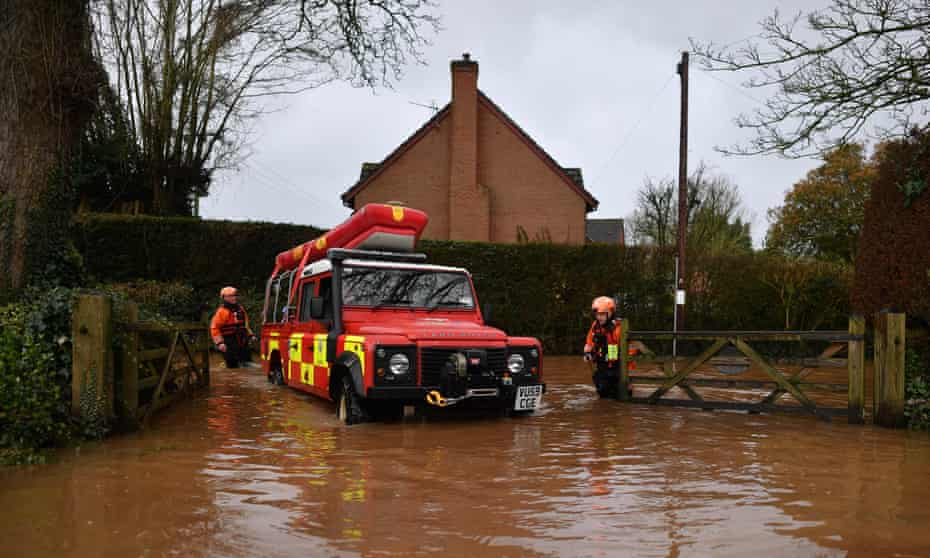Hereford Fire and Rescue personnel drive into a property cut off by flooding in the village of Hampton Bishop in Herefordshire.