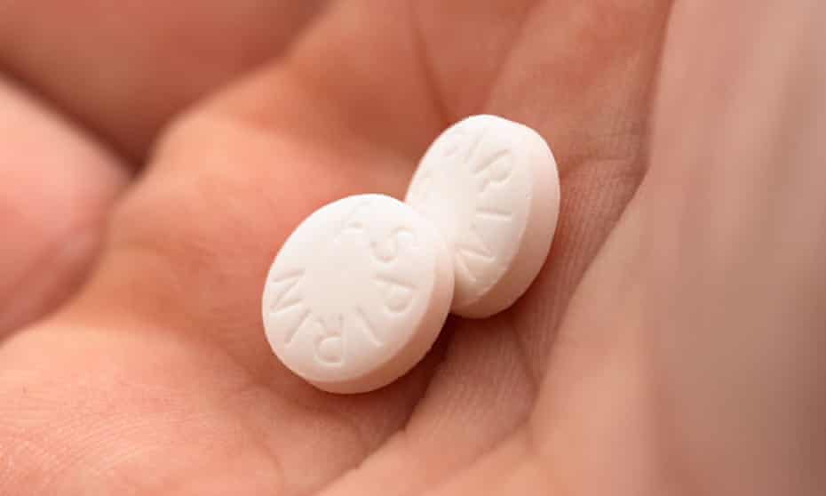 Two aspirin pills in the palm of a hand