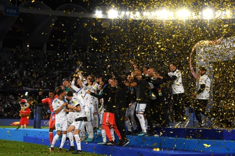 The Real Madrid players celebrate with the trophy under a flurry of shiny ticker-tape.