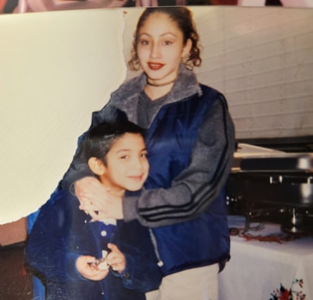a young boy is embraced by his older sister