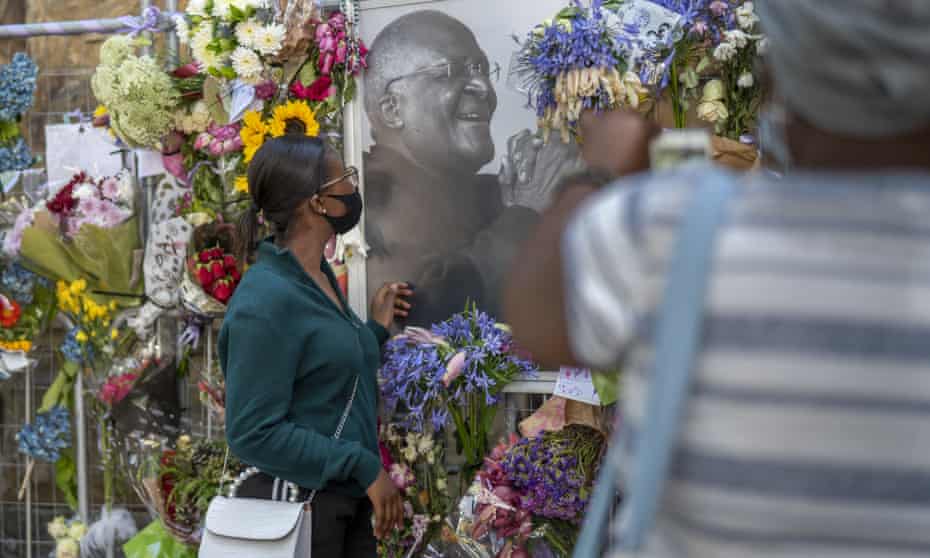 People read cards left with flowers in memory of  Desmond Tutu at St George's Cathedral on Friday.