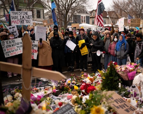 People gather at a makeshift memorial to Renee Good