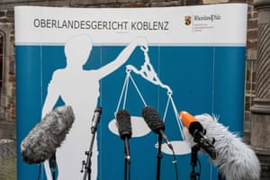 Microphones are set up in front of a banner ahead of a press conference outside the court in Koblenz, Germany.