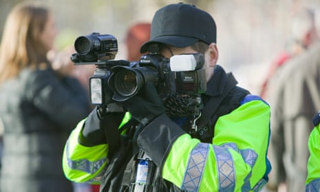A police photographer takes images of protesters at a climate change rally in London, December 2008.
