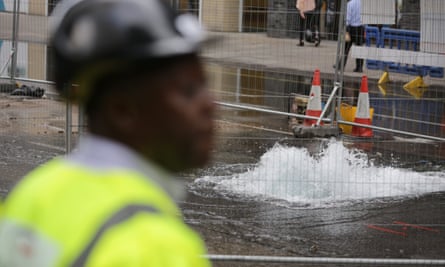 A maintenance worker stands in front of a burst water main on Victoria Street in Westminster, London. Picture date: Friday September 9, 2016.