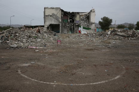 The partially demolished school building surrounded by debris.