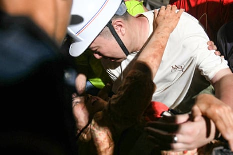 Ye Aung (top) accompanies his wife, Phyu Lay Khaing, on their way to the hospital after she was rescued from the rubble of the collapsed Sky Villa apartment building in Mandalay.