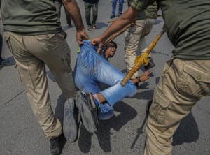 Srinagar, India: Policemen detain a Kashmiri Shia Muslim for participating in a banned procession marking the sacred month of Muharram
