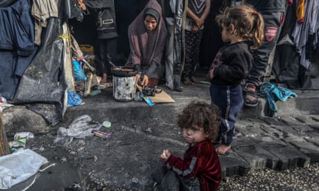 Palestinian families displaced from their homes make preparations for the iftar dinner in temporary tents in Rafah on Thursday.