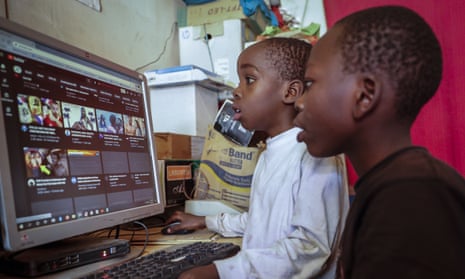 Two boys use a computer at an internet cafe in Nairobi, Kenya