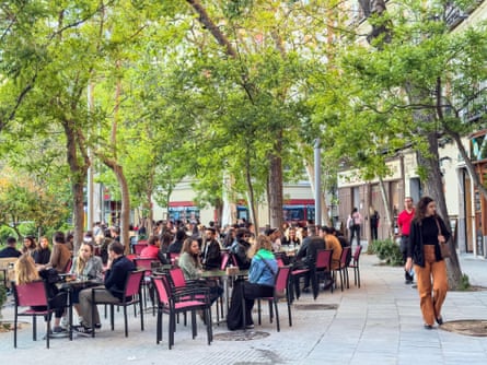 People dining outside under trees in the Plaza de Olavide, Chamberi.