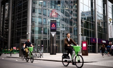 Cyclists ride e-bikes past the headquarters of NatWest bank in London in 2023. 
