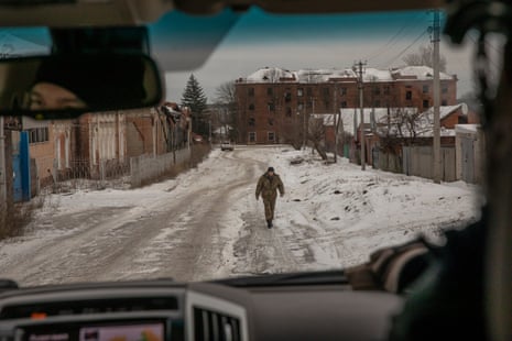 A soldier walks through the snowy streets of Kupiansk